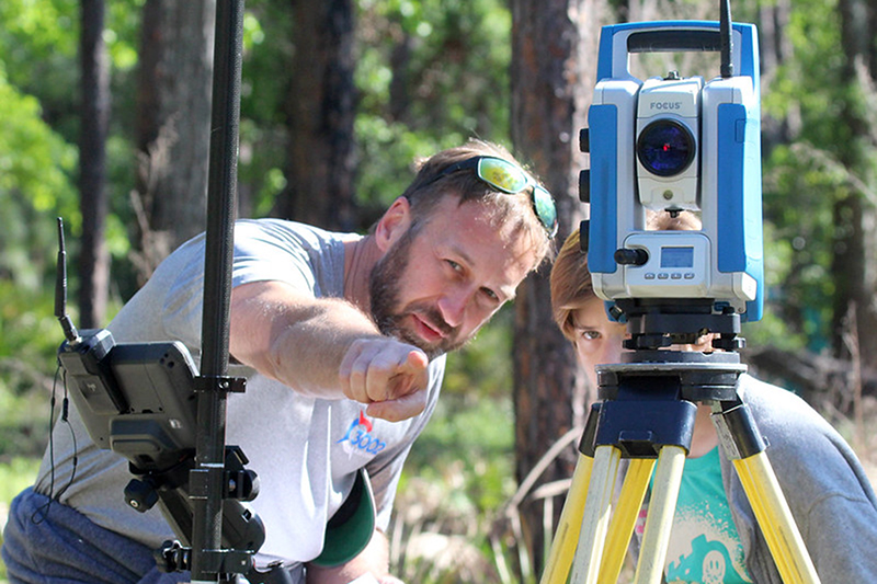 Brian Murphy, 3002 Surveying president, teaches Scouts how to replicate a boundary survey using the Total Station with a data collector./ Photo by SUZETTE COOK/SFFGS /Special to Alachua County Today