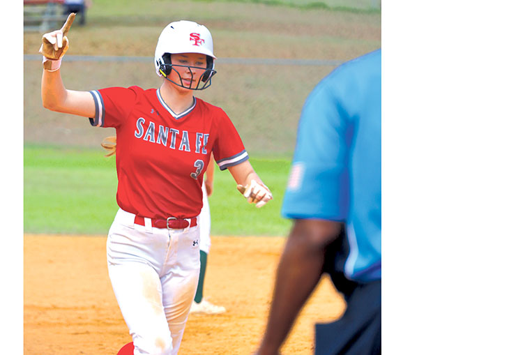 A Santa Fe Raider runner signals as she rounds the base during the 49th Annual Santa Fe Raider Softball Classic at Alachua’s Hal Brady Complex. The long-running tournament draws teams from across the region each season. / Photo by RILEY APPLEBEE